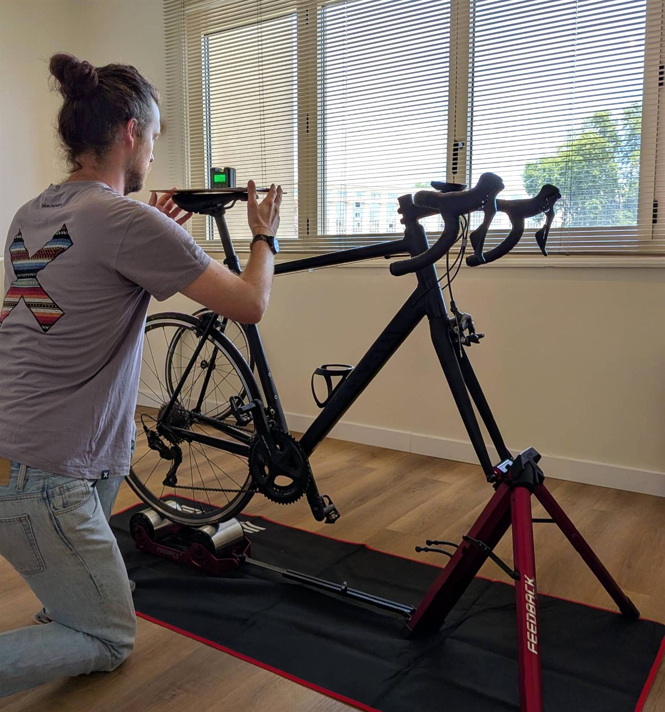 Analyse posturale du cycliste au Cabinet Port Juvénal : mesure de la hauteur de selle sur un vélo installé sur home trainer